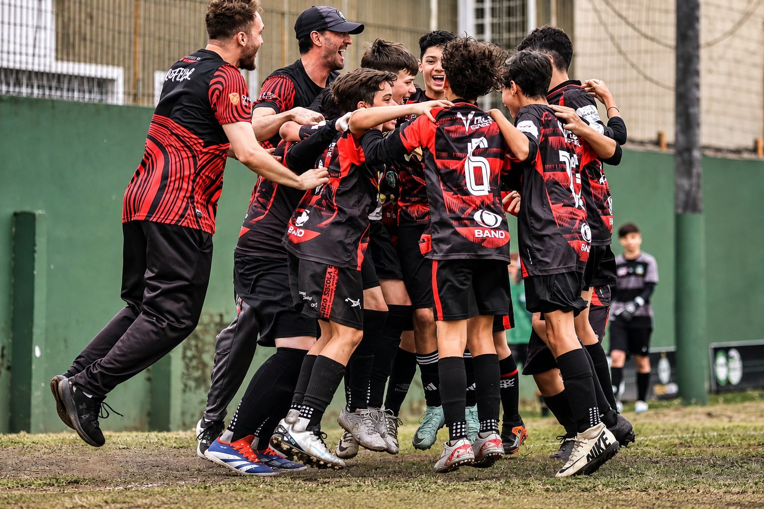 Jogadores e professor do Trieste se abraçando em comemoração